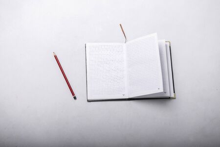 Notepad and pencil stand together on white background