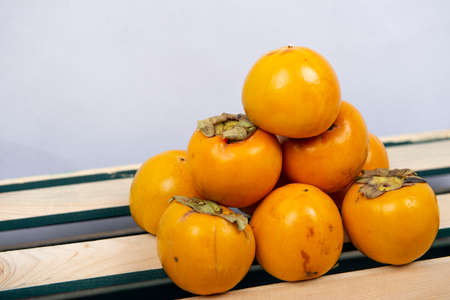 Fresh dates stand in front of a white background on a wooden case.の写真素材