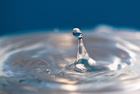 Falling Water Drops, with splashes, blue backgroundの写真素材