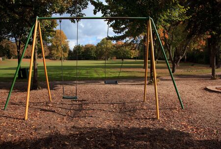 swing on empty playground in early autumn