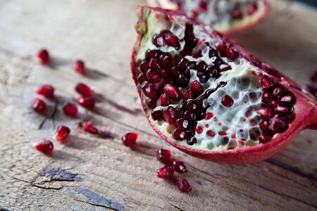 Pomegranate with arils on brown wooden boardの写真素材