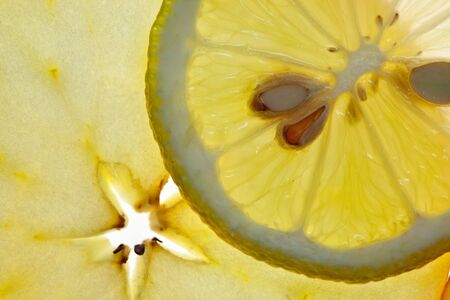 Sliced Lemon and Apple isolated on white with backlightの写真素材