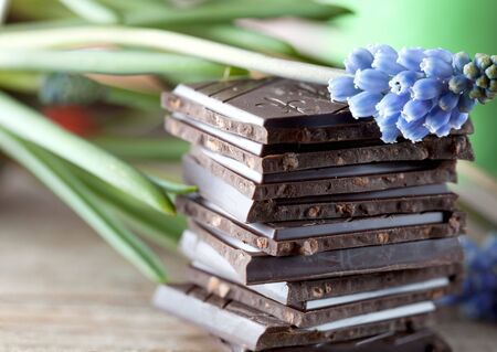 Decorative Stack of Chocolate on wooden board with flowerの写真素材