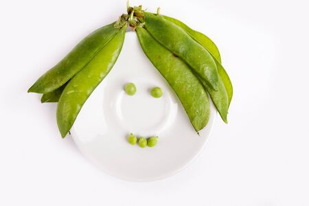 Fresh green peas on dish isolated on white studio shotの写真素材