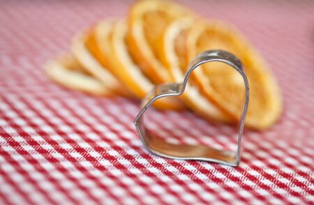 Dried Orange and  cookie cutter on chequered clothの写真素材