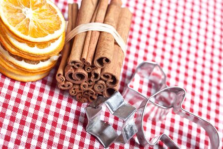 Dried Orange and Cinnamon Sticks on chequered cloth with cookie cuttersの写真素材