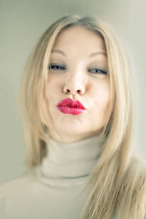 Portrait of a blonde woman pursing her lipsの写真素材