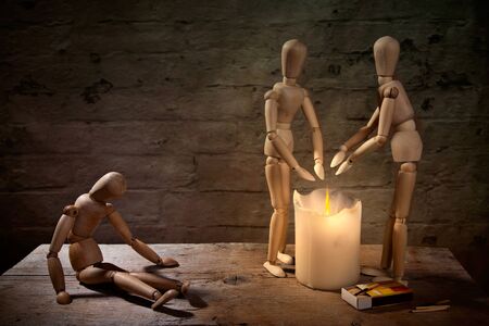 homeless dolls warming hand on fire with sick companionの写真素材