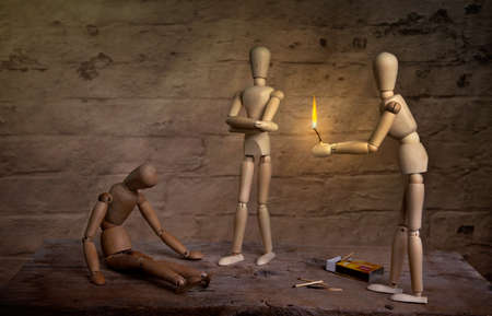 homeless dolls warming hand on fire with sick companionの写真素材