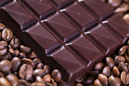 Fresh roasted coffee beans and bar of brown chocolate