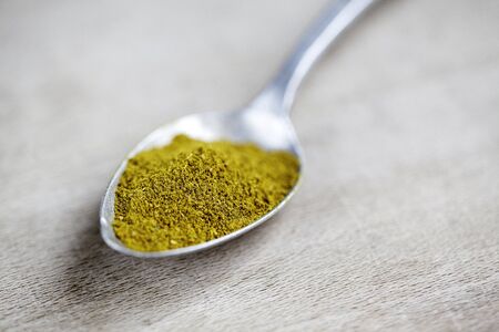 Spoon with yellow indian curry powderの写真素材