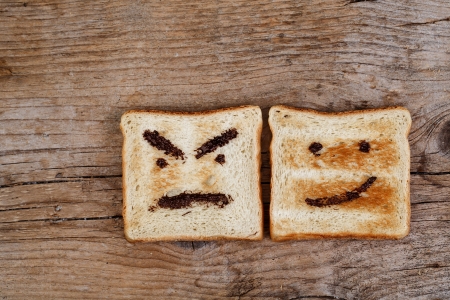 Toast Bread with happy and angry face painted with hazelnut chocolate spreadの写真素材