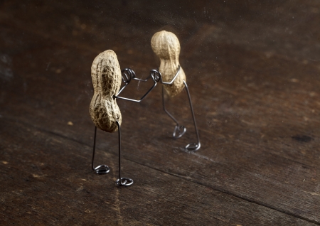 Couple of Peanut People being kept apart by a glass wall
