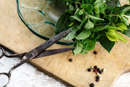 Thyme, Sage and Rosemary with Laurel bundled with cotton string and old rusty scissor on wooden...