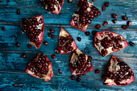 Fresh bright red Pomegranate on blue wooden backgroundの写真素材