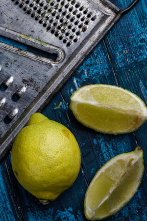 Fresh Lemon with metal grater on blue boardの写真素材