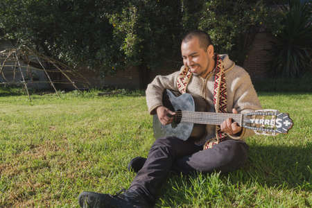 Musician holds guitar. A closeup portrait of a sacred man with traditional clothes