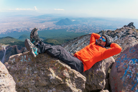 hiker taking a break resting on a rockの写真素材