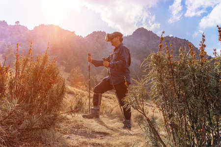 Man walking with VR glasses on mountainの写真素材