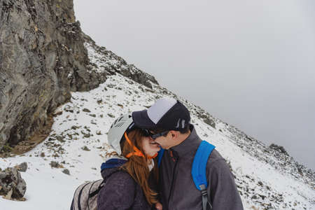 Side view of romantic young loving diverse couple in warm outerwear kissing with close eyesの写真素材