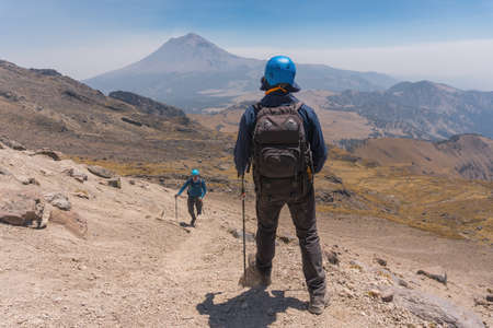Photograph of adventurous backpacker standing on mountain peak.の写真素材