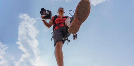 A MAN WALKING WITH A CAMERA IN HAND AND A SMART PHONE