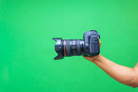 Camera in hands on isolated green screen
