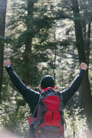 a portrait of male hiker with backpack and arms openの写真素材
