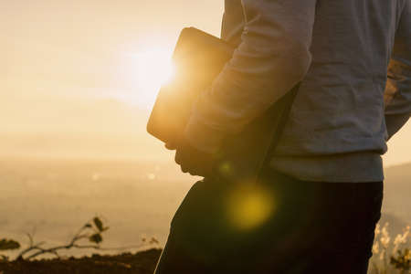 unrecognizable man with a laptop walking at sunriseの写真素材