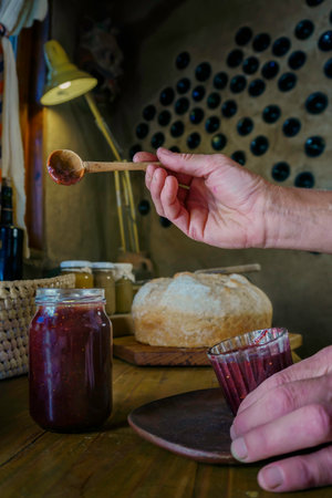 woman pouring fig jam into a jar