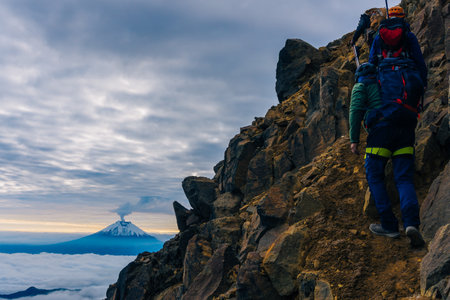 silhouettes of mountaineers at sunrise in the background the Cotopaxi volcanoの写真素材