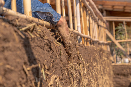 hands on a mud wall of a Latino man, bioconstruction techniqueの写真素材