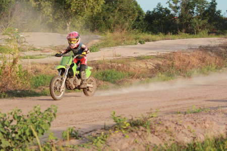 Rayong ,Thailand - JUNE 20, 2020 : Thai child Motocross racer accelerating in dirt trackl. in practice motocross field at Thailand.のeditorial素材