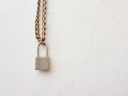 Key lock locked with a chain on the white wallの写真素材