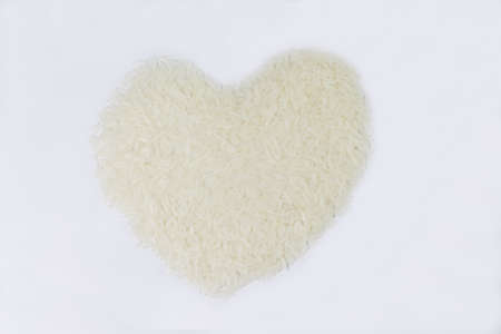Closeup uncooked Jasmine  rice heart shape for texture backgroundの写真素材