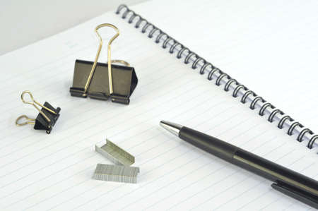 Empty spiral notebook with paper clip, pencil and penの写真素材