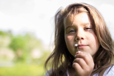 Closeup portrait of pretty girl with flower daisy in summerの写真素材