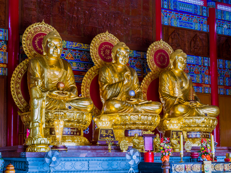 Three gold painted Chinese art Buddha statues in Thailand.のeditorial素材