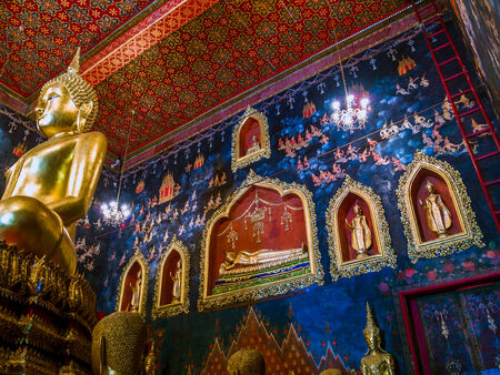 Ancient Buddha statue in Thailand with mural painting around.のeditorial素材