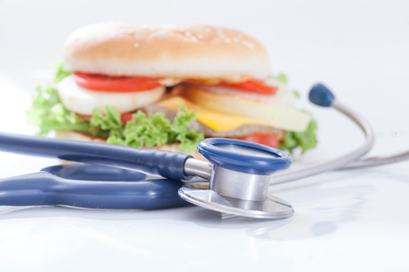 Cheeseburger & stethoscope on white backgroundの写真素材