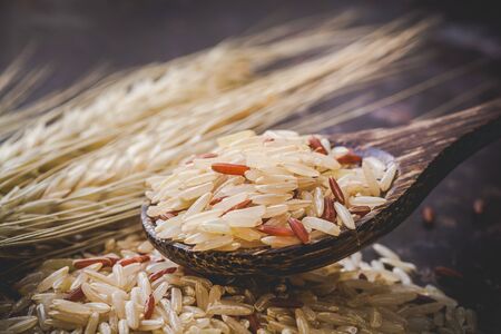 Brown rice in a wooden spoonの写真素材