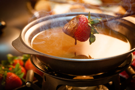 Chocolate fondue with oven on wooden tableの写真素材