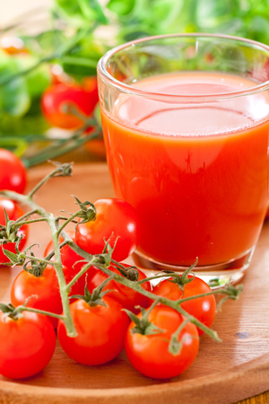 Tomato juice in a glass with tomatoの写真素材