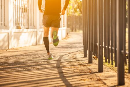 Man running on road at sunset