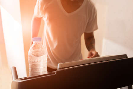 Man running on treadmill in fitness with waterの写真素材