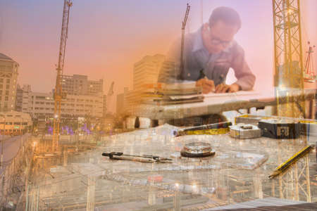 Architect man working with blueprints  in workplace for architectural plan,sketching a construction projectの写真素材