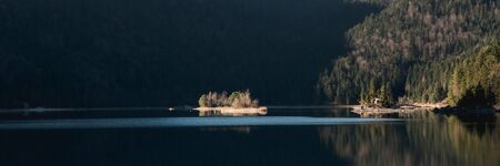 Idyllic winter landscape with crystal clear mountain lake in the Alps on a cold sunny dayの写真素材