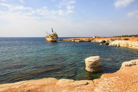 Seascape: boat EDRO III shipwrecked near the rocky shore at the sunset. Mediterranean, near Paphos. Cyprusの写真素材