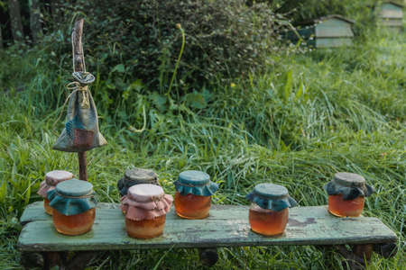Honey in a pot on a wooden table in the gardenの写真素材