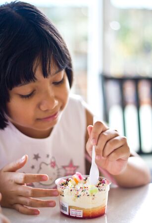 Asian girl eating cakeの写真素材